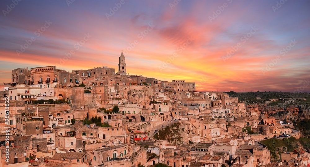 panoramic view of typical stones and church of Matera under sunset sky