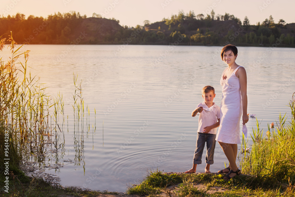 boy and mother plays with white paper boat boy and mother plays with white paper boat