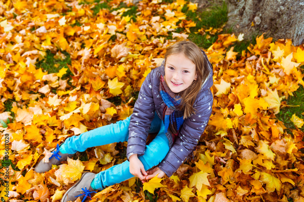 Autumn portrait of a cute little girl of 8 years old, playing with yellow leaves in the park Autumn portrait of a cute little girl of 8 years old, playing with yellow leaves in the park