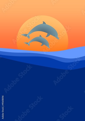 Two dolphins leaping above the waves of sea level at sunset with the setting orange sun in background and orange sky