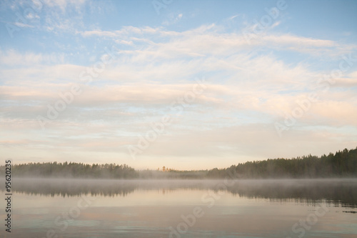 Forest at lakeside at foggy morning © Juhku