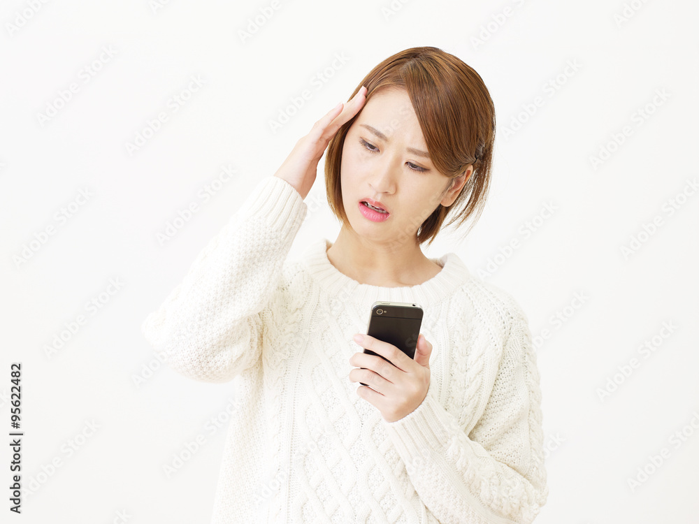 スマートフォンを持つ女性 悩む スマートフォンを持つ女性 悩む