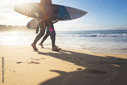 Australian surfers walking along Bondi Beach photo