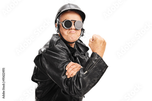 Cocky senior biker gesturing with gripped fist