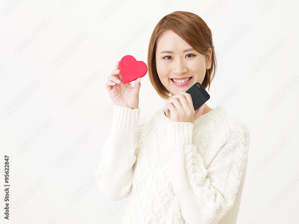 スマートフォンを持つ女性　ハートマーク