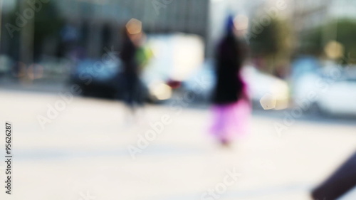 anonymous people walking fast in blurred and out of focus urban context photo