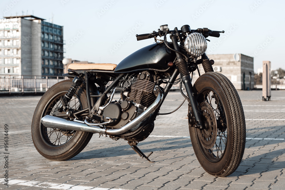 Obraz premium Vintage motorcycle in parking lot during sunset