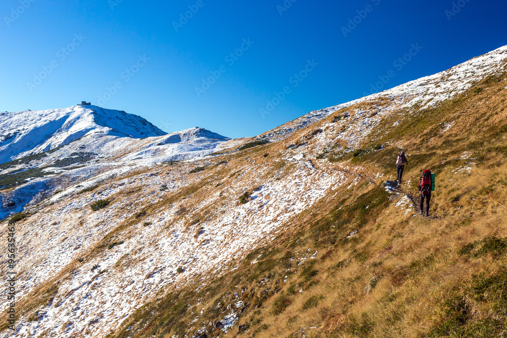 Winter Mountain Range View and Group of Trekkers Walking Up on Trail Winter Mountain Range View and Group of Trekkers Walking Up on Trail