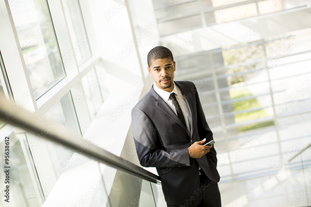Handsome young black man with mobile phone in the office Handsome young black man with mobile phone in the office
