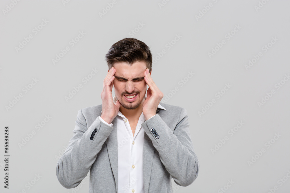 Young man with hands on temples suffering from headache Young man with hands on temples suffering from headache
