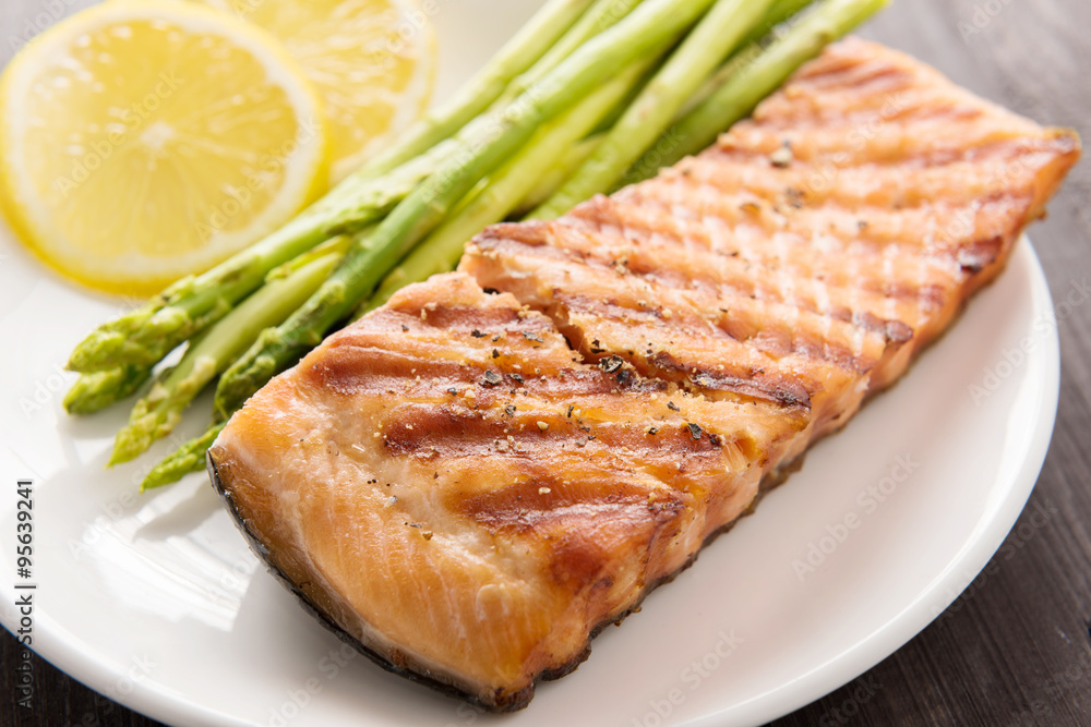 Grilled salmon and lemon, asparagus, on the wooden table Grilled salmon and lemon, asparagus, on the wooden table