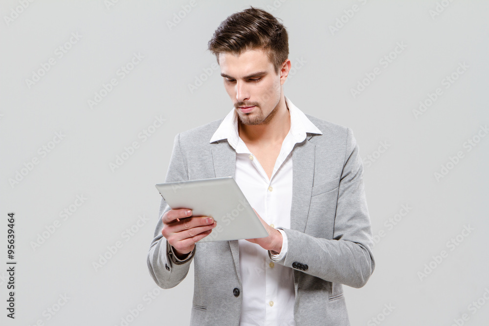 Concentrated young businessman using tablet Concentrated young businessman using tablet