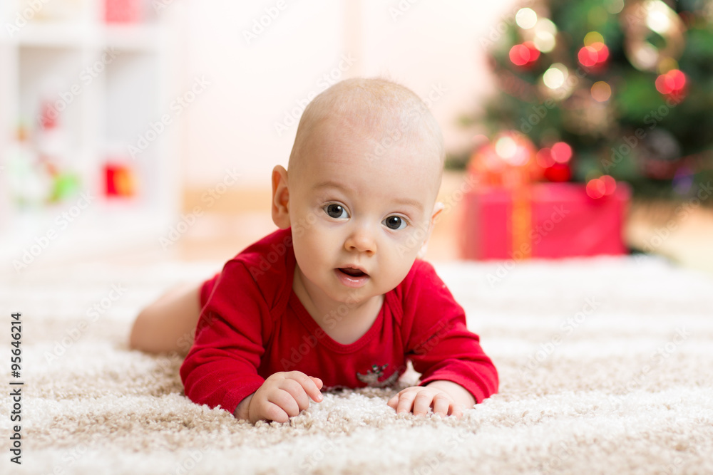 Funny baby in Santa Claus clothes with xmas tree Funny baby in Santa Claus clothes with xmas tree