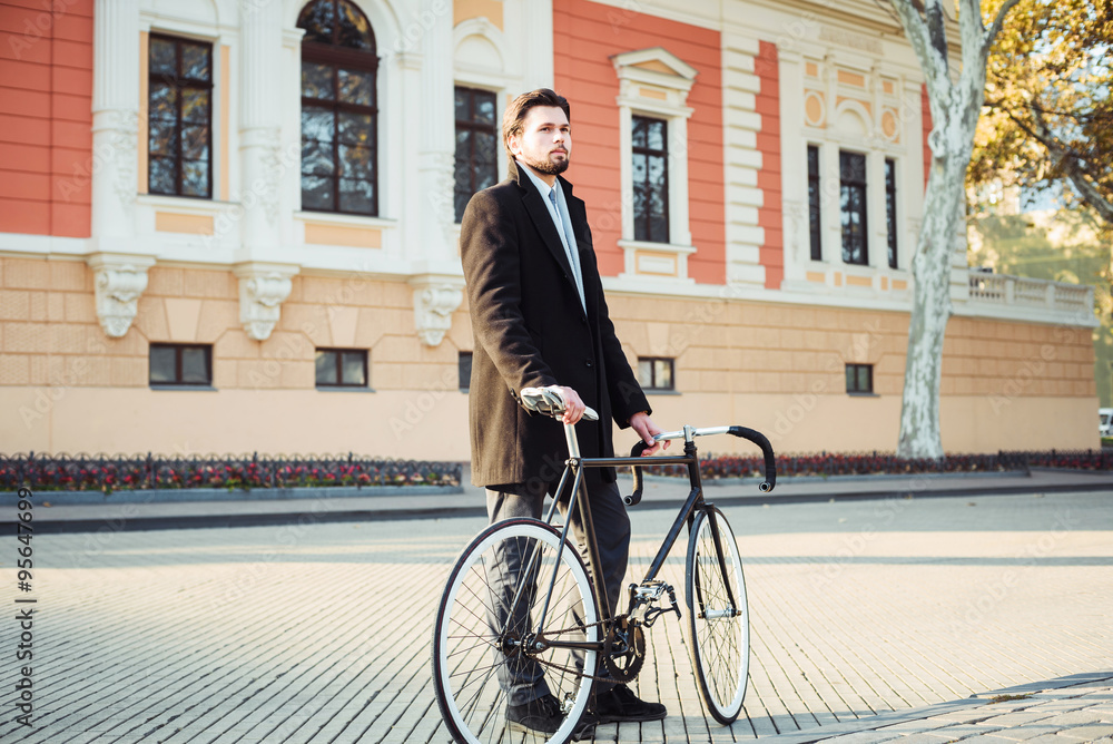 Obraz premium young caucasian businessman with bicycle