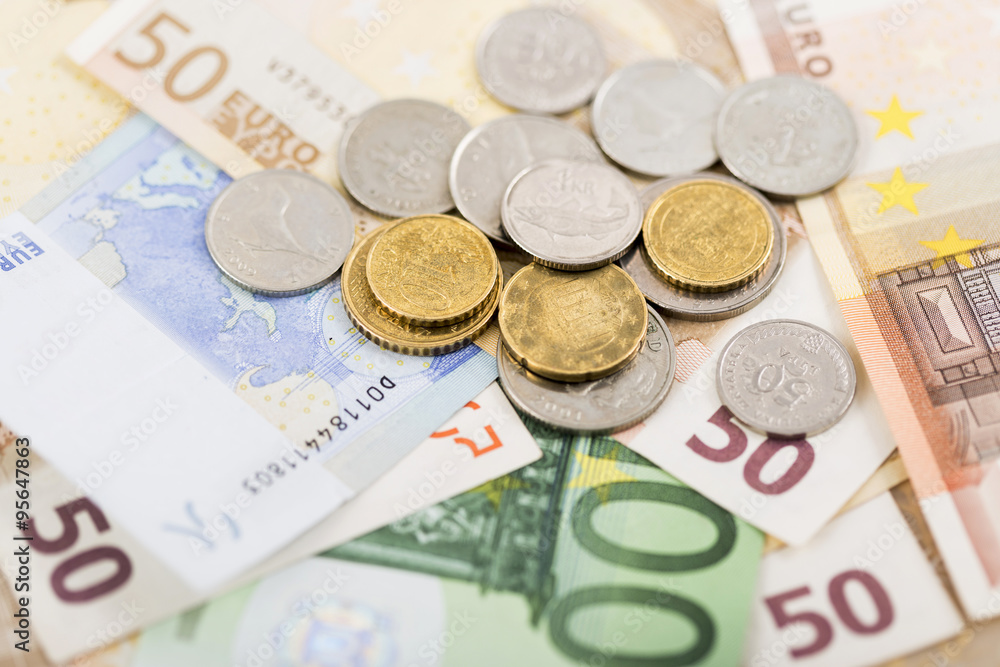 business, finance, investment, saving and cash concept - close up of euro paper money and coins on table business, finance, investment, saving and cash concept - close up of euro paper money and coins on table
