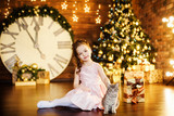 Little girl with a cat in a holiday room