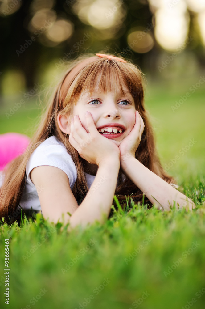Funny red-haired girl relaxing on the grass in the park Funny red-haired girl relaxing on the grass in the park