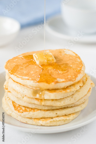 Stack of pancakes with butter and honey