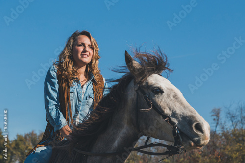 Pretty girl riding her grey horse