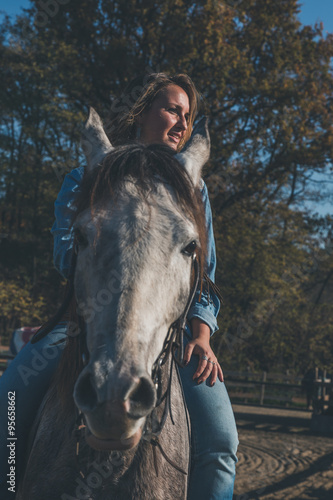 Pretty girl riding her grey horse © tinx