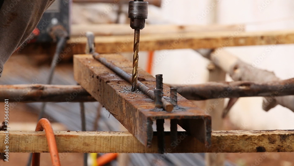 Drilling steel metal with hand drill at construction site Drilling steel metal with hand drill at construction site