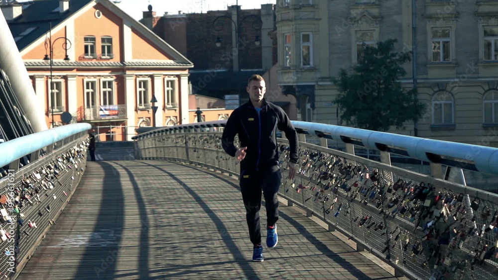Young man jogging on the bridge in the city, super slow motion
Young man jogging on the bridge in the city, super slow motion