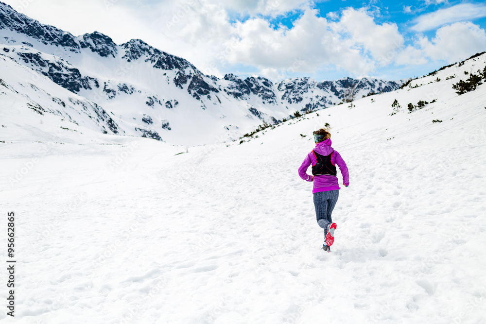 Happy woman winter trail running in beautiful inspirational land