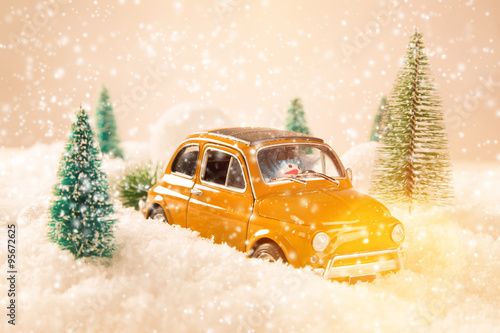 Miniature yellow car with spruce trees