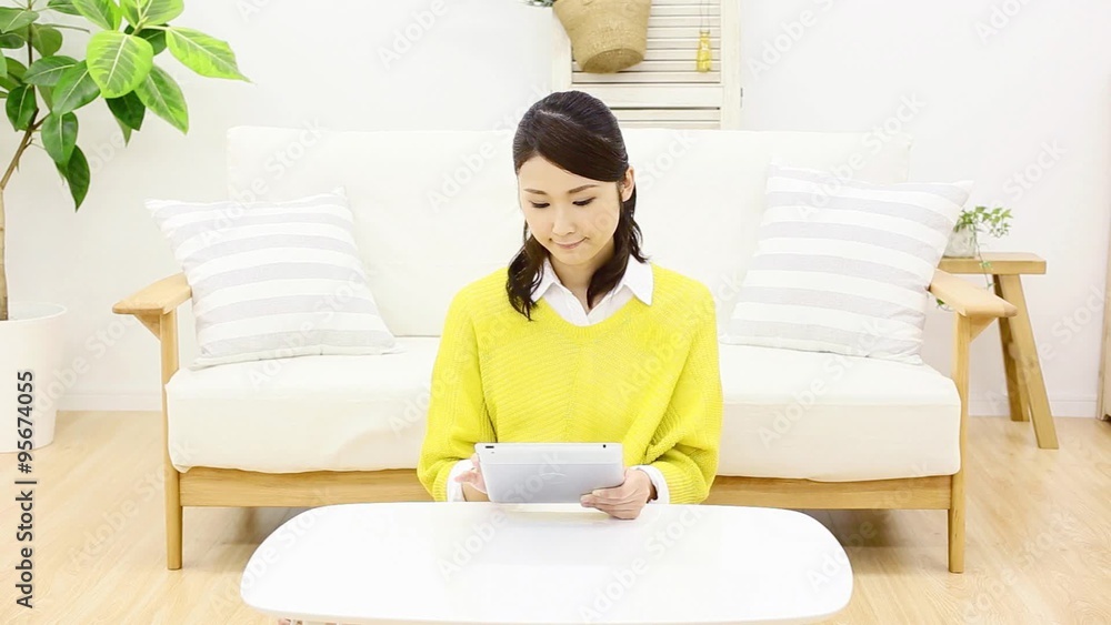 部屋でタブレットを使う女性　考える