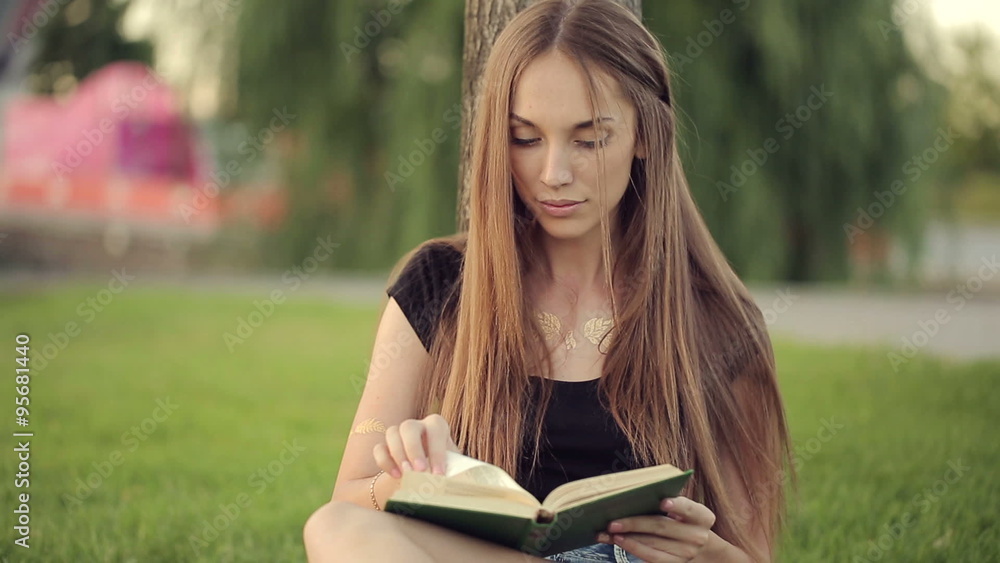Woman Reading Book By The Tree In Park Woman Reading Book By The Tree In Park