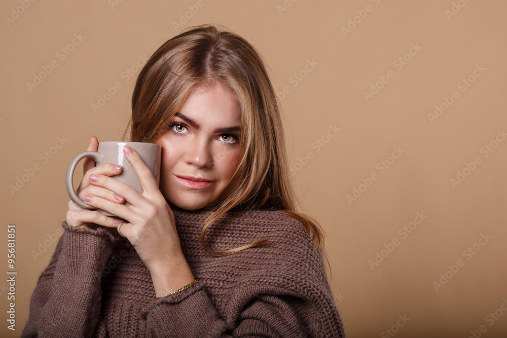 Girl in warm sweater drinking a warm beverage from a mug. Girl in warm sweater drinking a warm beverage from a mug.