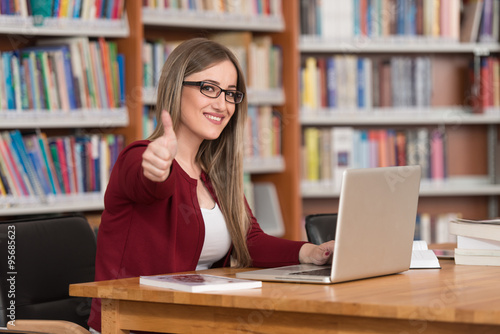 Young Woman In A Library Showing Thumbs Up
