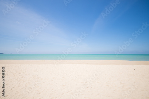 tropical beach with blue sky and calm blue sea surf