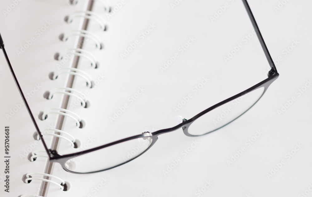 Eyeglasses on opened spiral notebook Eyeglasses on opened spiral notebook