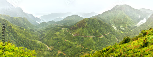 Panorama O Quy Ho Pass in the morning, Lao Cai, Vietnam with roads winding through the rugged mountain range. It was chosen as the Pass the four most beautiful and rugged Northwest Vietnam