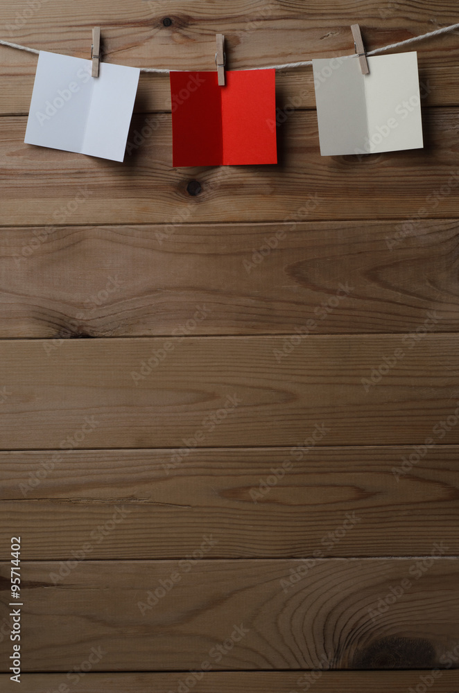 Fototapeta premium Three Opened Greetings Cards Pegged to String on Wood Planking