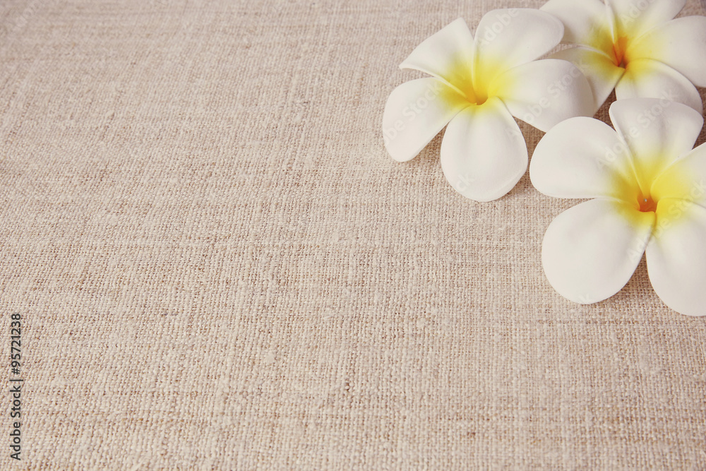Artificial Plumeria flowers on linen, copy space background, selective focus Artificial Plumeria flowers on linen, copy space background, selective focus