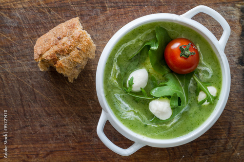 Arugula and tomatoes puree soup in white bowl photo