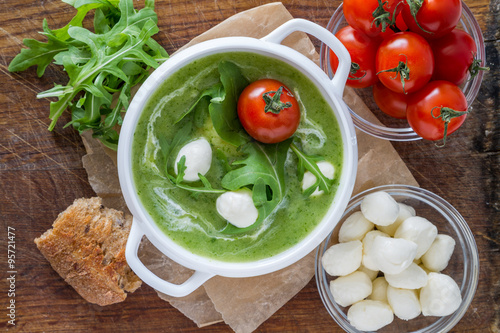 Arugula and tomatoes puree soup in white bowl photo