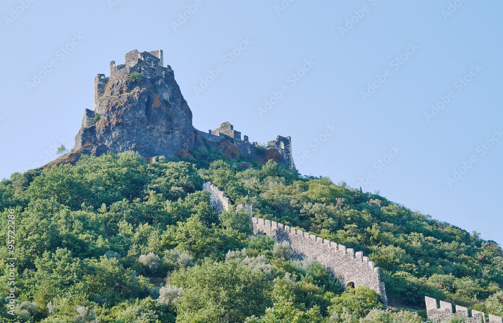 Stone ruins of a medieval castle on a hilltop in France.