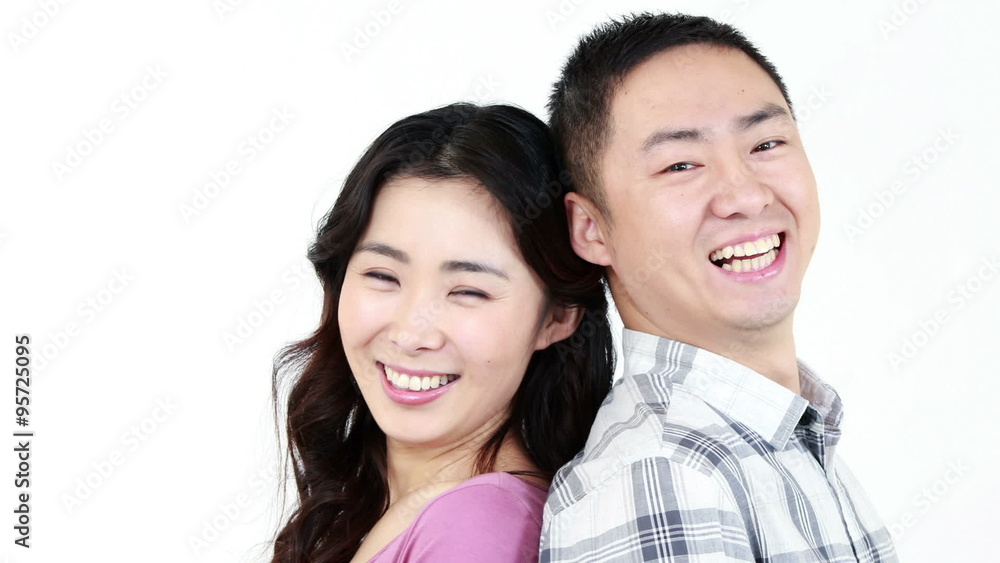 Smiling couple showing their thumbs at the camera Smiling couple showing their thumbs at the camera