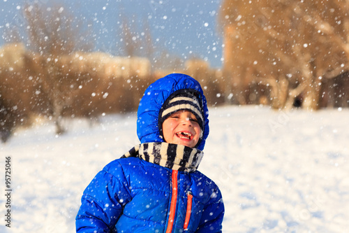 little boy enjoy snow in winter nature