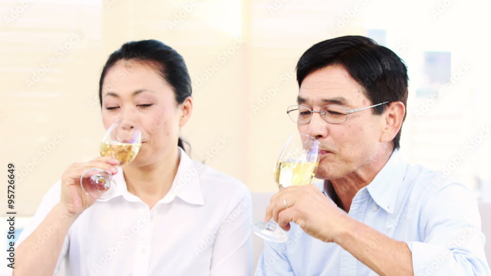 Mature couple tasting champagne on the sofa Mature couple tasting champagne on the sofa