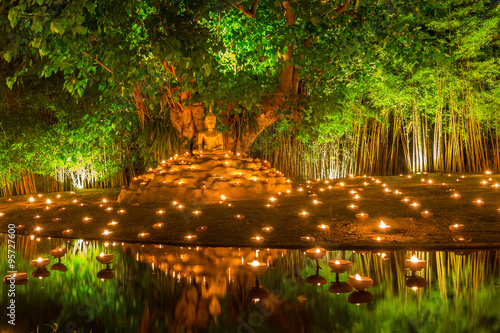 Buddha image with mediation prosture placed under Bodhi with many candles for commemorate Visakha Bucha day.