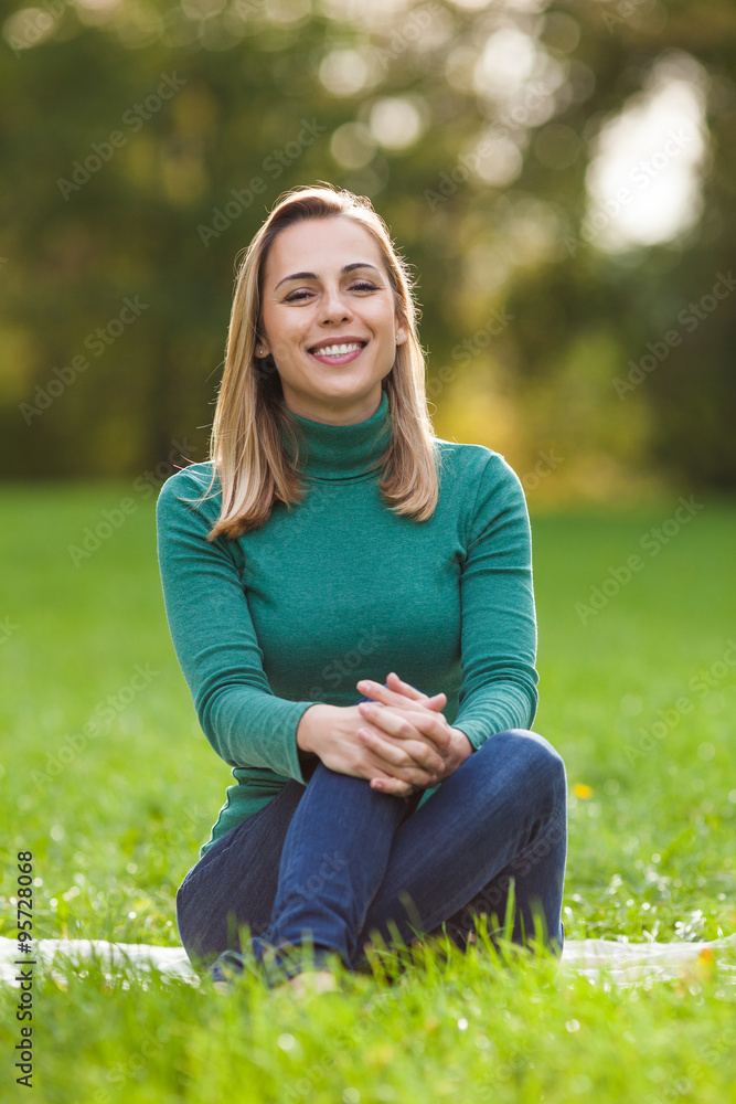Happy woman sitting in park and enjoying nature Happy woman sitting in park and enjoying nature
