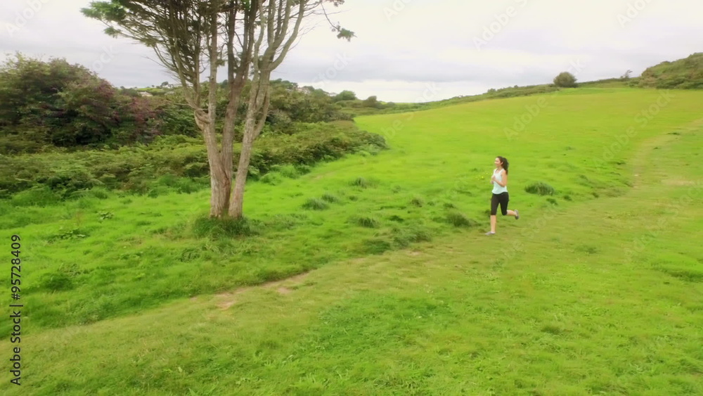 Fit woman running in a green landscape Fit woman running in a green landscape