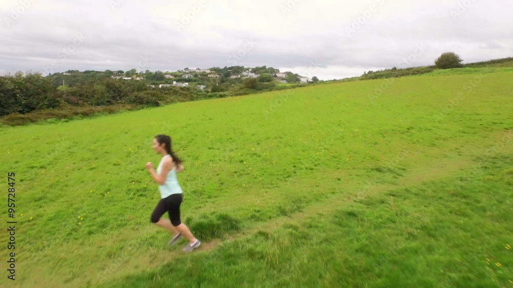 Fit woman running in a green landscape Fit woman running in a green landscape