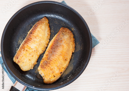 Fried fish fillet in a frying pan