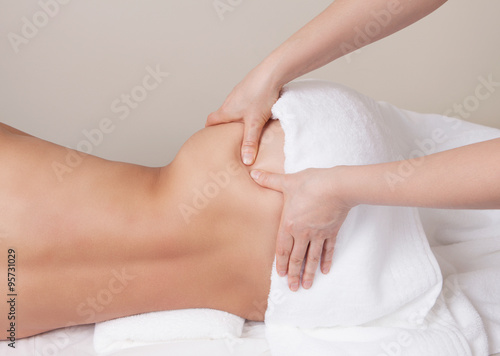 Qualified therapist  doing pressure point massage on a woman's hip