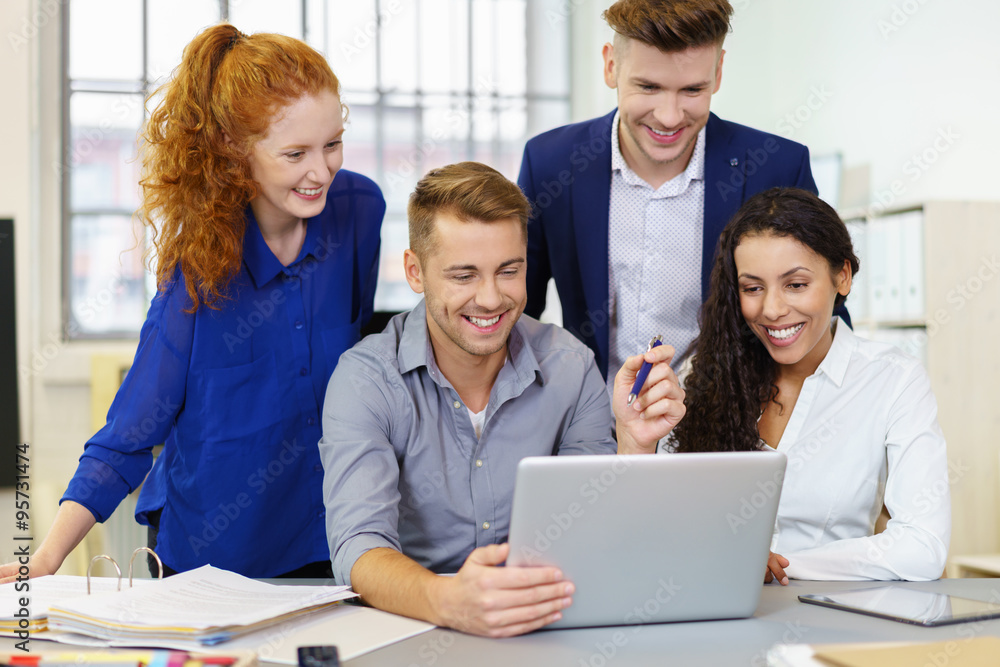 kollegen schauen lachen auf laptop im büro